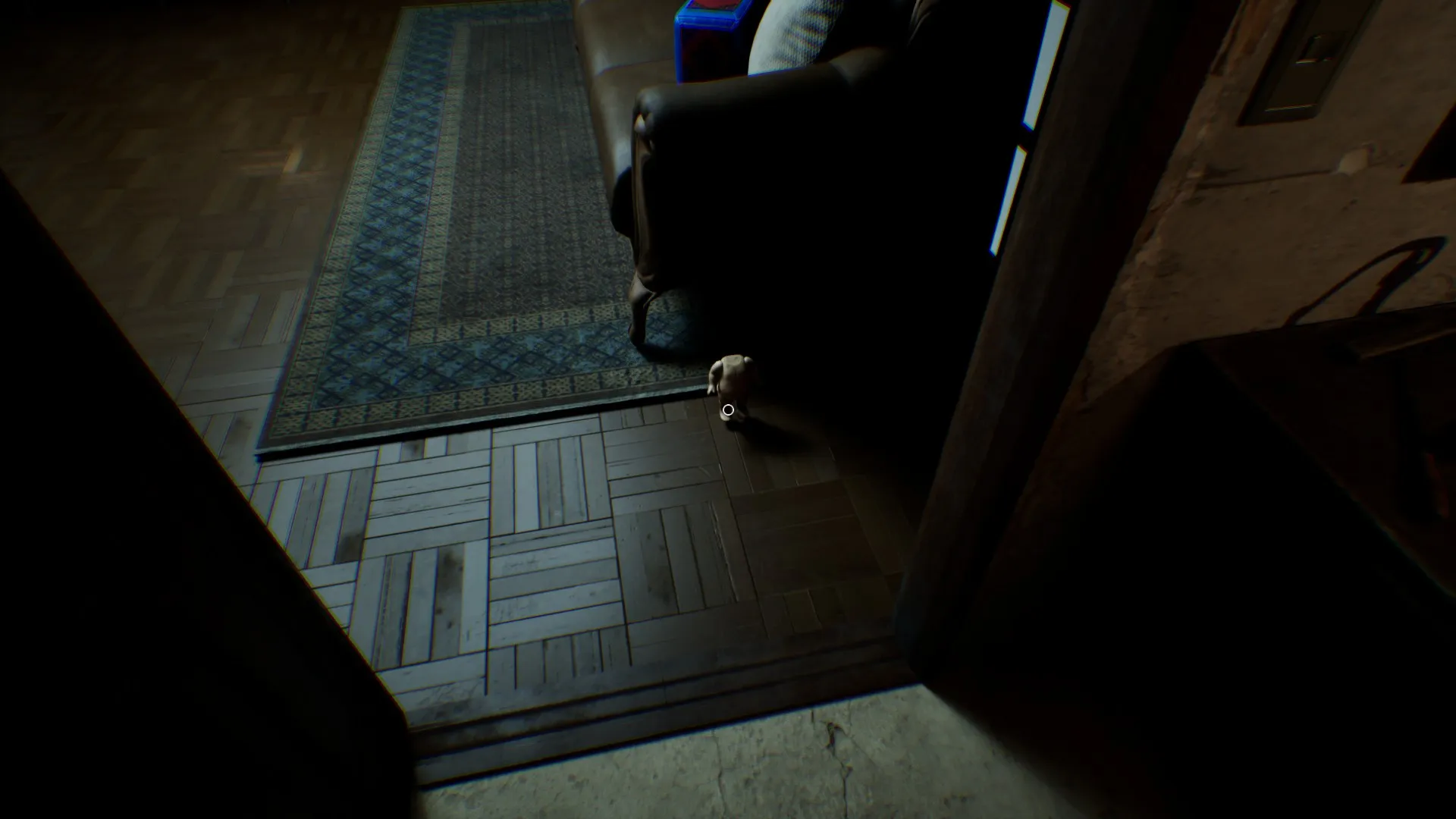 A creepy doll appears on the floor next to the couch.