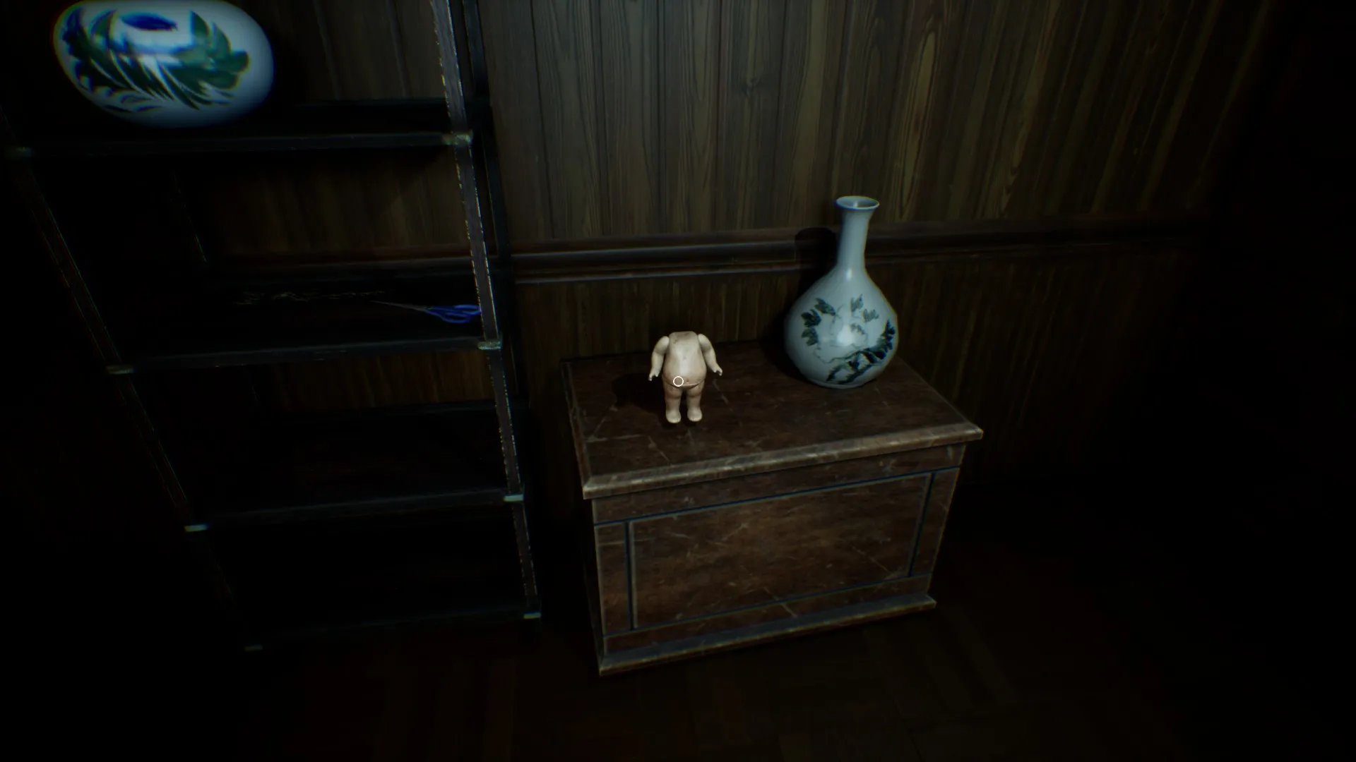 The creepy doll has moved and is now sitting next to a vase.